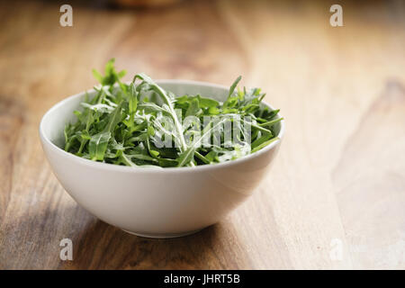 Fresco verde insalata di rucola foglie di rucola in ciotola bianco Foto Stock