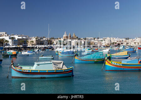 Paesaggio con colorate barche da pesca Luzzus, Marsaxlokk, Malta Foto Stock