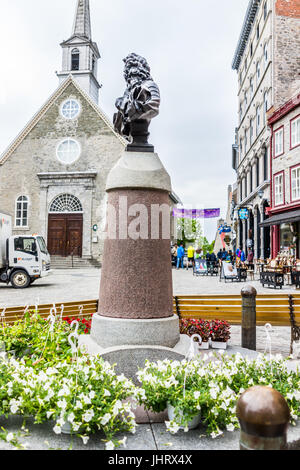 La città di Quebec, Canada - 30 Maggio 2017: Inferiore città vecchia strada con statua busto di Luigi XIV e fiori su Place Royale con Notre Dame des Victoires c Foto Stock