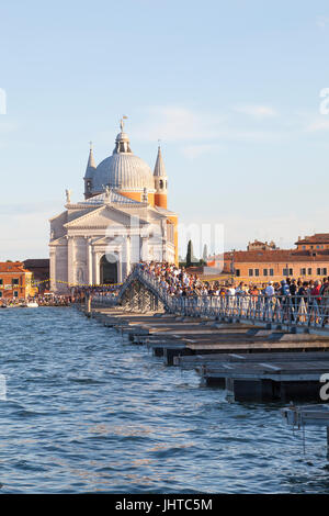 Venezia, Italia. Il 15 luglio 2017. 15 luglio Venezia, Italia. Le persone che attraversano il ponte votivo alla Chiesa del Redentore al tramonto che è stata costruita in onore di Cristo Redentore in ritorno per far finire la pestilenza del 1575 al 1577 in cui oltre 50000 persone, quasi un terzo della popolazione, morì. La peste è stata dichiarata conclusa il 13 luglio 1577 e a questo giorno Venezia celebra questo evento ogni terza domenica del mese di luglio con la Festa de la Festa del Redentore. Credito: Maria Clarke/Alamy Live News Foto Stock