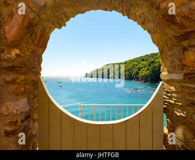 Un cancello con una bella vista della baia di Cawsand visti attraverso un cirle parete incorniciata e cancello in legno, Cornwall, Inghilterra Foto Stock