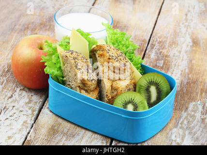 Scuola di sano pranzo composto da marrone a sandwich di formaggio, frutta fresca e bicchiere di latte Foto Stock