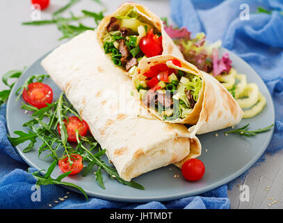 Shawarma da succosa carne di manzo, lattuga, pomodori, cetrioli, la paprika e la cipolla nel pane pita. Menù dietetici. Foto Stock