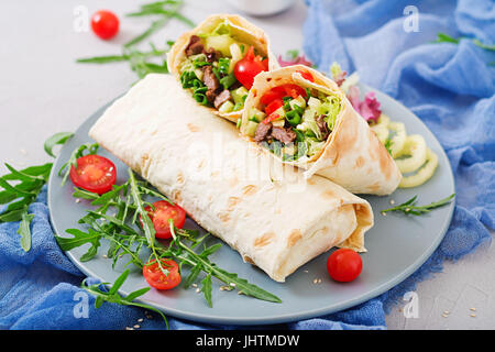 Shawarma da succosa carne di manzo, lattuga, pomodori, cetrioli, la paprika e la cipolla nel pane pita. Menù dietetici. Foto Stock