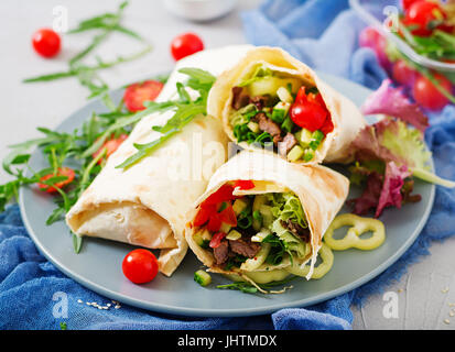 Shawarma da succosa carne di manzo, lattuga, pomodori, cetrioli, la paprika e la cipolla nel pane pita. Menù dietetici. Foto Stock