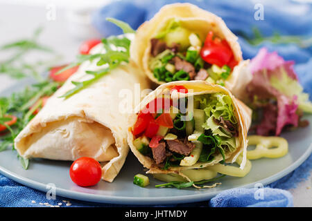 Shawarma da succosa carne di manzo, lattuga, pomodori, cetrioli, la paprika e la cipolla nel pane pita. Menù dietetici. Foto Stock