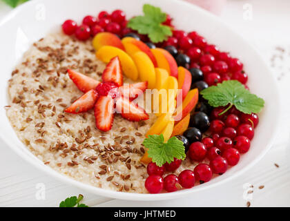 Gustosa e salutare i fiocchi d'avena porridge con berry, semi di lino e frullati. Una sana prima colazione. Cibo per il fitness. Una corretta alimentazione Foto Stock