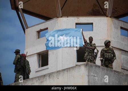 Soldati somali e membri del Ras Kimboni volare milizie somale bandiera nazionale dall'ex torre di controllo dell'aeroporto di Kismayo mentre celebrano la sua cattura da Al Qaeda affiliate del gruppo estremista al Shabaab Ottobre 2, 2012 in Kismayo, Somalia. (Foto di Stuart Prezzo via Planetpix) Foto Stock