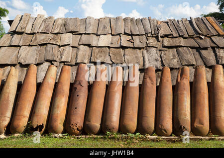 Deadly harvest lasciati dalla Guerra del Vietnam. Una parete di ruggine americana involucri bomba riciclato per l'uso in Xiangkhouang, Provincia, Laos Foto Stock