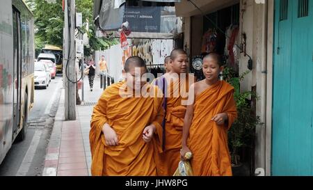 Il monachesimo giovani zafferano tunica arancione Theravada Scuola Buddista Wat Yannawa Boy monaci camminare su Sathorn Road di Bangkok in Thailandia Foto Stock