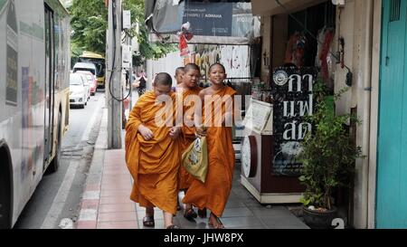 Il monachesimo giovani zafferano tunica arancione Theravada Scuola Buddista Wat Yannawa Boy monaci camminare su Sathorn Road di Bangkok in Thailandia Foto Stock