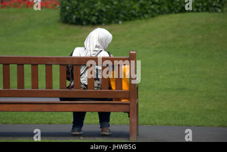 Famiglia asiatica rifugiato giovane donna una studentessa allievo vestito Hijab sciarpa su strada nel Regno Unito scena quotidiana camminando sulla strada Foto Stock