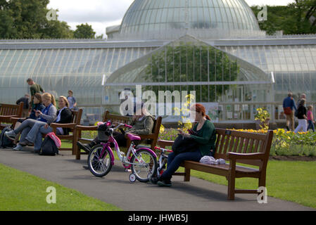 Botanic Gardens Glasgow giornata soleggiata famiglia con bici fuori serra sul banco di lavoro Foto Stock