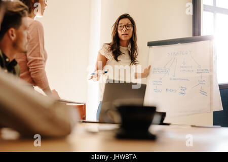 Donna manager discutere di nuova strategia aziendale con il team della sala conferenze. Imprenditrice durante la presentazione in office board camera. Foto Stock