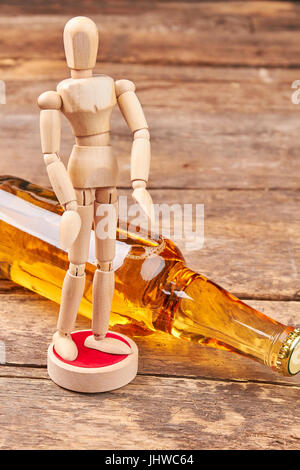 Human manichino di legno, bottiglia di alcool. Foto Stock