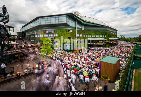 La folla si raccolgono al di fuori centro corte come essi attendere per Roger Federer a sfilare il trofeo su una corte centrale balcone dopo aver battuto Marin CILIC in colleghi Singoli Final il giorno tredici dei campionati di Wimbledon al All England Lawn Tennis e Croquet Club, Wimbledon. Foto Stock