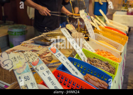 Cucina di strada bancarella vendendo carbone essiccato grigliate di pesce in Tai O villaggio di pescatori di Hong Kong. Foto Stock