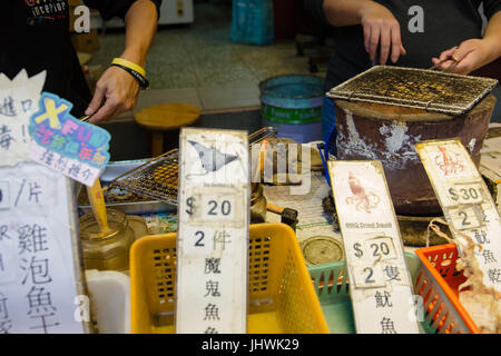 Cucina di strada bancarella vendendo carbone essiccato grigliate di pesce in Tai O villaggio di pescatori di Hong Kong. Foto Stock