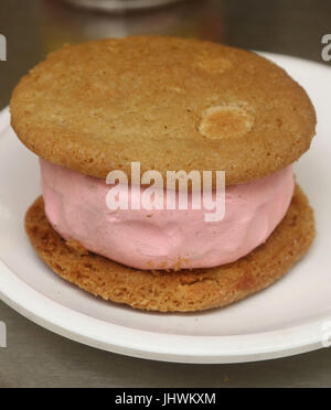 Strawberry ice cream sandwich realizzati con due biscotti alla vaniglia e gelato alla fragola il riempimento Foto Stock