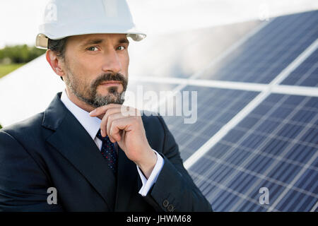 Ritratto di client in casco bianco a energia solare stazione. Foto Stock