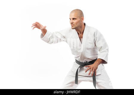 Giovane uomo lottatore in un kimono bianco con la cintura nera di judo, jujitsu pongono sulla isolato sfondo bianco Foto Stock