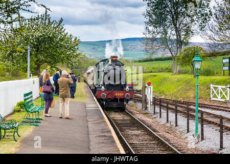 Ex-GWR loco 6960 'Raveningham Hall' arriva nella stazione di Washford con un treno di Vescovi Lydeard sulla West Somerset Railway, REGNO UNITO Foto Stock