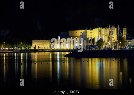 Vecchia stazione di potenza e il porto è illuminato di notte. Riva del Garda. Il lago di Garda. Italia Foto Stock