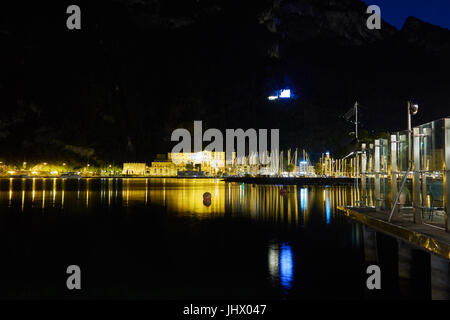 Vecchia stazione di potenza e il porto è illuminato di notte. Riva del Garda. Il lago di Garda. Italia Foto Stock