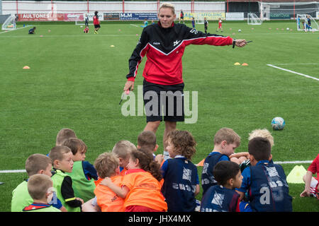 Femmina allenatore di calcio per insegnare ai bambini Foto Stock