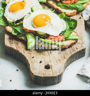 Crostini di pane con uova fritte e verdure fresche, quadrato ritaglia Foto Stock