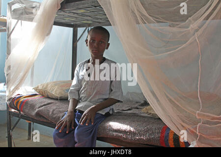 Maiduguri, Nigeria. Il 30 giugno, 2017. Mohamed Abdullahi (10) seduta su di un letto in un ONU-run tranist Centre nel nord-est della città di Maiduguri, Nigeria, 30 giugno 2017. Egli è stato rapito da Boko Haram e interrogato dopo la sua liberazione dai militari nigeriani. Dal momento che il suo rilascio, egli ha vissuto nel centro di transito. Foto: Kristin Palitza/dpa/Alamy Live News Foto Stock