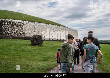 Gruppo di persone che camminano verso Newgrange neolitico Età della pietra tomba di passaggio in Bru na Boinne Co. Contea di Meath, Irlanda newgrange tomba di passaggio Foto Stock