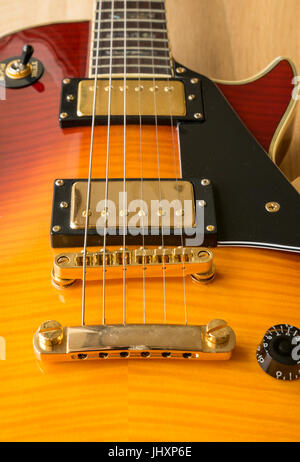 Close up di ciliegia Westfield Les Paul chitarra elettrica, luce sullo sfondo di legno con controlli di tono e volume del raccoglitore e il selettore Foto Stock