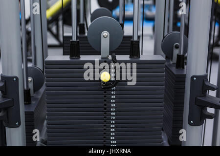 Ferro nero piastre pesanti impilati di peso macchina in palestra per il fitness. Sport piastre di simulatore Foto Stock