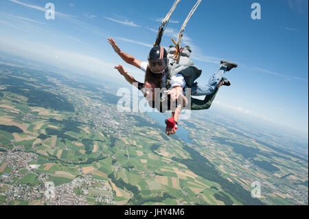 Ragazza facendo un primo skydive in tandem Foto Stock