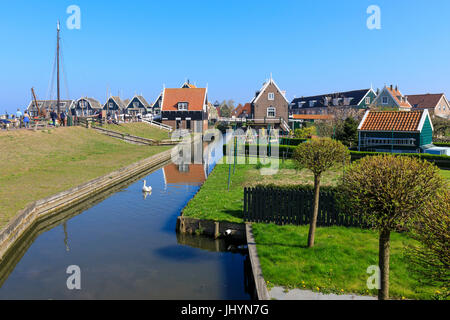 Il White Swan nel canale circondato da prati e tipiche case in legno, Marken, Waterland, North Holland, Paesi Bassi Foto Stock