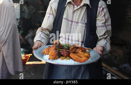 Anantnag, India. 16 Luglio, 2017. Wazwan è un multi-pasto nella cucina del Kashmir, la cui preparazione è considerato un'arte e un punto di orgoglio nella cultura del Kashmir e identità. Quasi tutti i piatti sono a base di carne con carne di agnello o di pollo. È famoso in tutta la questione del Kashmir, inoltre, Wazwan è servita anche a livello internazionale in Kashmir sagre e riunioni.nella lingua del Kashmir, waz significa 'cuocere' o 'Cucina' e mezzi di wan 'shop'. La ultimate banchetto solenne in Kashmir è il royal wazwan. Credito: Aasif Shafi/Pacific Press/Alamy Live News Foto Stock