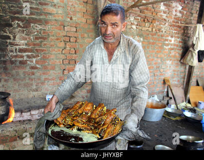 Anantnag, India. 16 Luglio, 2017. Wazwan è un multi-pasto nella cucina del Kashmir, la cui preparazione è considerato un'arte e un punto di orgoglio nella cultura del Kashmir e identità. Quasi tutti i piatti sono a base di carne con carne di agnello o di pollo. È famoso in tutta la questione del Kashmir, inoltre, Wazwan è servita anche a livello internazionale in Kashmir sagre e riunioni.nella lingua del Kashmir, waz significa 'cuocere' o 'Cucina' e mezzi di wan 'shop'. La ultimate banchetto solenne in Kashmir è il royal wazwan. Credito: Aasif Shafi/Pacific Press/Alamy Live News Foto Stock