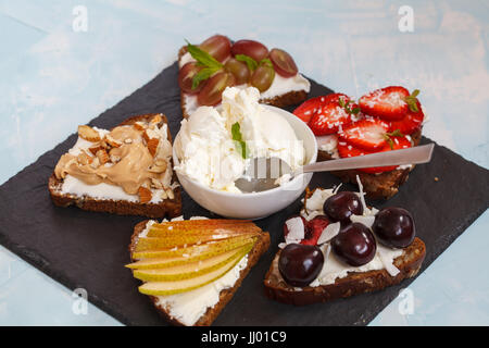 Panini dolci con mascarpone e frutti di bosco, pera e burro di arachidi. Foto Stock