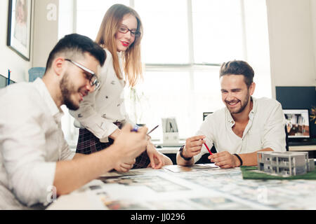 Fiducioso team di ingegneri che lavorano insieme in uno studio di architetto Foto Stock