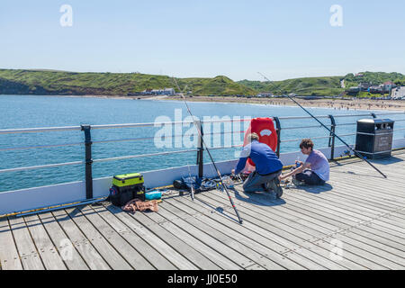 Due ragazzi la pesca dal molo Saltburn dal mare,Inghilterra,UK Foto Stock