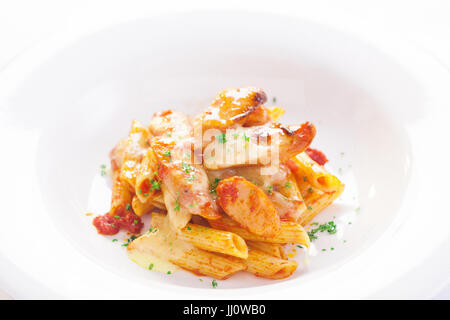 Penne pasta cotta con salsiccia e crema piccante salsa di pomodoro Foto Stock