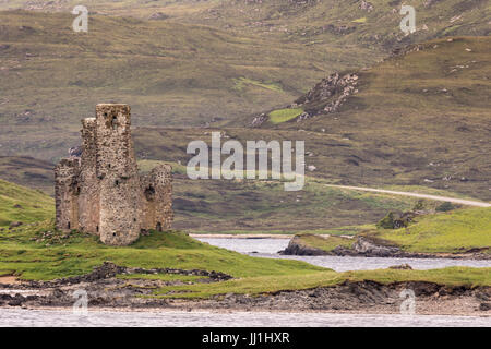 Penisola Assynt, Scozia - Giugno 7, 2012: marroncina rovine del castello da Ardvreck sul Loch Assynt. La massa verde della vegetazione. Marrone pendio di montagna. Foto Stock