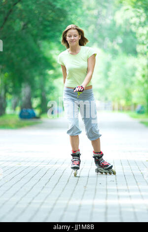 Roller Skating sportivo ragazza nel parco con i rollerblade sul pattino in linea Foto Stock