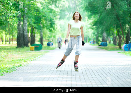 Roller Skating sportivo ragazza nel parco con i rollerblade sul pattino in linea Foto Stock