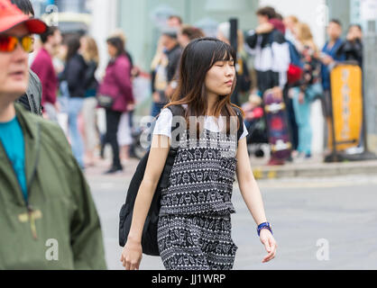 Giovane donna giapponese camminare da solo con gli occhi chiusi in una città frenetica NEL REGNO UNITO. Fiducioso turista giapponese. Foto Stock