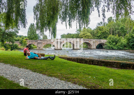 La famiglia presso un ponte medievale che attraversa il fiume Exe a Bickleigh Devon. A cinque arcata in pietra ponte che attraversa il fiume Exe seguito Tiverton, costruita nel 1809 a Foto Stock