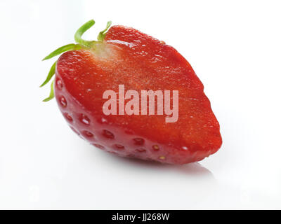 Primo piano della red organic homegrown fragole mature tagliate a metà isolato su sfondo bianco Foto Stock