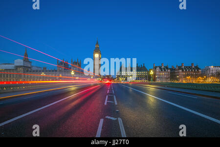 Londra, Inghilterra - Big Ben e le Camere del Parlamento adottate dal centro di Westminster Bridge al tramonto con le luci delle vetture e autobus che passa da Foto Stock