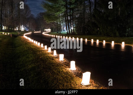 Burke, Stati Uniti - 24 dicembre 2016: la vigilia di Natale luci di candela in sacchi di carta di notte lungo la strada illuminata da case in neighborh residenziale Foto Stock